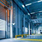 Spacious and modern warehouse interior with parked truck and steel structures.