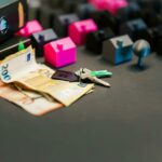 Miniature houses, euro bills, and a house key symbolize real estate investment and property transactions.